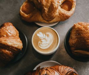 Tasse de café et viennoiseries sur une table en bois